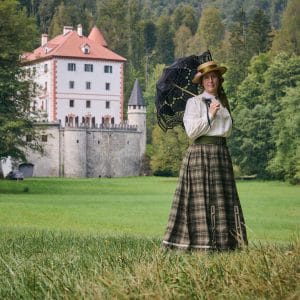 Countess Greta with a parasol in front of Snežnik Castle